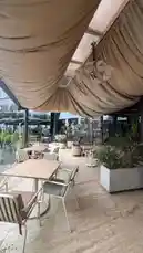 Explore a beautifully styled outdoor café space with draped fabric canopies, modern furniture, and lush greenery. This serene setting offers inspiration for creating inviting patios and garden lounges. by @om.louraa with original sound