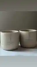A serene showcase of two minimalist ceramic cups, beautifully inscribed with Arabic calligraphy and the name 'Abdulmjeed Aryam.' These artisanal pieces highlight modern design fused with traditional cultural elements, perfect for coffee lovers seeking unique, handcrafted tableware. by @r200an with original sound