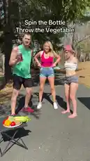 Three friends gather around a table with vegetables in a sunny park setting. A man spins a bottle on the ground, and as it stops, the women react with surprise and laughter. The game takes a comical turn when one woman throws a vegetable, leading to a chaotic and funny moment. This outdoor challenge is filled with unexpected reactions and playful energy. by @chriscolditz with Original Sound by chriscolditz