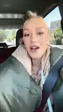 In this candid moment, Gwen Stefani and her husband Gavin Rossdale share a joyful car ride. Gwen, dressed casually in a beige hoodie and green bomber jacket, smiles brightly and playfully interacts with the camera. Her husband, wearing a baseball cap and glasses, drives while also engaging with her. The atmosphere is lighthearted and full of laughter, capturing a genuine slice of their everyday life together. by @gwenstefani with Original Sound by gwenstefani