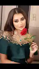A captivating still image from aljawharah Artist's content features a model with flawless makeup, elegant dark green ruffled dress, and a striking emerald necklace. She holds a single red rose, creating a romantic and sophisticated aesthetic. The 'J.A.' logo suggests a professional beauty or fashion brand, making this ideal for inspiration on makeup artistry, styling, and visual branding. by @aljawharah_art with original sound