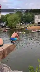 Watch this thrilling moment as a man leaps from a rocky cliff into a lake below, creating a massive splash. The surrounding area is filled with people enjoying a day out on the water, with boats and docks visible in the background. by @digiflips with Original Sound by digiflips