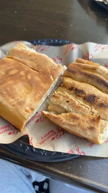 오리지널 사운드 포함 @rebeccaperi 님이 만든 In this close-up, high-quality shot, fitness and wellness influencer Beccaperifitmodel shares a simple, nutritious snack moment. The camera focuses on a golden-brown flatbread, sliced and resting on branded parchment paper. The warm, rustic aesthetic and focus on food suggest a candid lifestyle or 'day in the life' segment. This visual is ideal for SEO due to its clarity, relevance to health-conscious audiences, and clear subject matter.