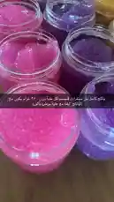 A close-up tour of Semsema Herbal Beauty's colorful sugar scrub collection. The camera pans across jars filled with pink, purple, orange, and brown scrubs, highlighting their glittery textures and vibrant colors. by @semsemallc25 with جمالو جمالو by فهد القصير