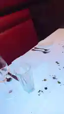 This vlog-style clip captures a birthday dinner at the upscale restaurant Capital Grille. It begins with a close-up of a beautifully set table adorned with a 'Happy Birthday' card. The camera then pans across the elegant dining room, showcasing festive holiday decorations including a Christmas tree and a prominent statue. A server is seen pouring red wine into a glass, and the meal concludes with a delicious-looking dessert plate featuring a lit candle, creating a warm and celebratory atmosphere. by @riserachelruth with original sound