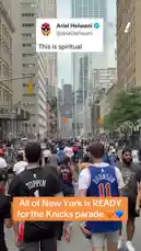 A massive crowd of New York Knicks fans fills a city street in celebration, many wearing team jerseys. The atmosphere is electric as supporters gather for what appears to be a victory parade. This energetic scene captures the spirit of a city united behind its beloved basketball team. by @yahoosports with Original Sound by yahoosports