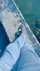abdoufall205962 님이 만든 Original Sound 포함 @abdoufall205962 님이 만든 A serene point-of-view shot captures someone relaxing by the water's edge. The camera focuses on their legs, clad in light-colored pants and stylish transparent sandals, as they sit on a weathered concrete ledge. The gentle lapping of the water creates a tranquil atmosphere, perfect for a peaceful moment.