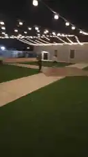 This nighttime scene captures a lively outdoor gathering under a canopy of string lights. Several people are seen enjoying various activities on a grassy area with concrete walkways. The atmosphere suggests a casual party or social event, possibly hosted by Maksim Kochkin. by @kochkinmax with kochkinmax by Original Sound