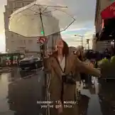 Watch Zenith Aurelius transform a gloomy city street into her personal runway. In this captivating scene, she stands confidently under a transparent umbrella, arms outstretched against the wet pavement and overcast sky. Her chic trench coat and radiant smile turn a simple rainy day into a powerful moment of self-expression. The text overlay 'november 17, monday: you've got this.' adds a layer of motivational energy, making it a perfect visual for anyone seeking inspiration to conquer their week. This is more than just a walk; it's a statement. by @zenith_aurel with zenith_aurel by Contains: Die With A Smile - Lady Gaga, Bruno Mars