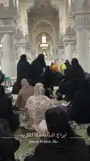 This immersive video offers a rare glimpse into a peaceful women-only gathering within the grand halls of the Masjid al-Haram in Makkah, Saudi Arabia. Viewers see women dressed in traditional black abayas and hijabs, some seated on ornate prayer rugs while others engage in quiet conversation or study. The majestic white marble architecture, towering columns, and elegant arches create a breathtaking backdrop. One woman is seen reading from a book, possibly religious texts, highlighting the spiritual and educational aspects of the event. The atmosphere is one of solemnity and community, capturing a moment of cultural and religious significance. by @om.louraa with original sound