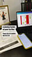 A static shot displays a desk setup featuring a laptop with a calendar open, a smartphone, and printed materials. A prominent text overlay in French announces that October's schedule is now open for bookings, providing a phone number for appointments. A framed poster of SANA K® Paris is visible in the background, establishing the brand identity. by @sanakparis with original sound