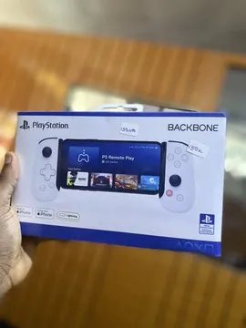 A close-up view of a hand holding the retail packaging for the PlayStation Backbone controller. The box clearly displays the white controller with its integrated screen, highlighting features like 'PS Remote Play' and 'DualShock 4 & DualSense'. This unboxing-style presentation is designed to attract viewers interested in the latest gaming hardware. by @frekasglobal with original sound