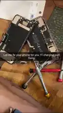This short-form tutorial shows a disassembled iPhone, focusing on the internal components like the logic board and battery, with tools laid out for repair. A text overlay states 'Let me fix your phone for you 11 charging port fixing,' indicating the video's purpose is to demonstrate how to fix an iPhone 11's charging port issue. by @authority421 with Original Sound by authority421