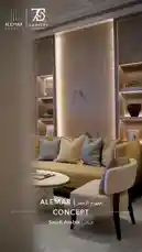 A luxurious living room design by ALEMAR CONCEPT, showcasing sophisticated decor elements such as a beige sofa with stylish cushions, a marble coffee table, and a striking illuminated wall mural depicting birds on branches. The space features modern lighting fixtures, built-in shelves displaying books and decorative items, and a minimalist aesthetic that blends contemporary comfort with artistic flair. by @alemarconcept with alemarconcept by Original Sound