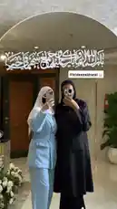 In a beautifully decorated indoor setting, Haneen and her friend capture a selfie moment before the wedding. Dressed in stylish hijabs and modern attire—a light blue suit and a chic black coat—they pose beneath an elegant arch adorned with Arabic calligraphy. This candid scene offers a glimpse into contemporary Muslim bridal preparations, showcasing modest fashion, friendship, and the joyous anticipation of a special day. by @me_ha73 with original sound