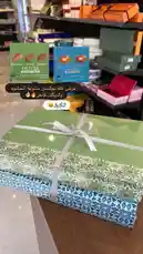 A beautifully arranged display of premium chocolate gift boxes, including Olivia brand specialties like Raspberry, Blueberry, and Salted Caramel. The scene highlights elegant packaging, perfect for gifting, with Arabic text overlay suggesting a promotional offer. This unboxing-style visual showcases the luxurious appeal of these chocolates, ideal for special occasions. by @ch11.30 with original sound