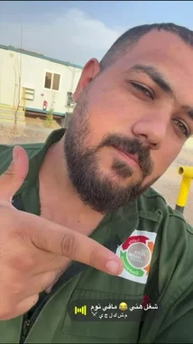 A close-up selfie shows a man in an Egyptian Air Force uniform proudly pointing to a new 'Zero Harm Environmental' patch on his olive green flight jacket. He is outdoors in a sunny, arid environment near temporary buildings. The scene captures a moment of military pride and environmental awareness. by @vii35_1 with Original Sound by vii35_1