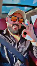 في هذا المشهد، يظهر سيف DJ وهو يجلس في مقعد السيارة، يرتدي قبعة بيضاء ونظارات شمسية ذات عدسات برتقالية، ويُظهر إشارة 'أوك' بإبهامه وإصبعه السبابة. يرتدي قميصًا داكنًا مخططًا وحزام الأمان، ويبدو أنه يستمتع برحلة أو يلتقط لحظة من رحلته. تضيء أشعة الشمس المحيطة بالمشهد، مما يوحي بأن الوقت هو نهار صافٍ، وتحيط به أجزاء من الداخلية الفاخرة للسيارة، بما في ذلك المقاعد الحمراء. يعكس المشهد جوًا من الثقة والراحة، ويبرز شخصية سيف DJ كشخصية عصرية وعالية الطاقة. by @djsefo with original sound