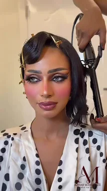 Watch آزهار المنوآشي💄 get ready for her big moment in this behind-the-scenes look at her transformation. The video captures her styling her hair with a curling iron, showcasing her flawless makeup with bold brows, dramatic lashes, and a soft pink lip. She then elegantly poses in a beautiful gold dress, highlighting her stunning earrings and overall glamorous aesthetic. by @azhron1234 with Original Sound by azhron1234