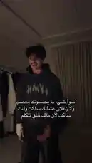 في هذا المشهد من محتوى بدر القحطاني، يظهر وهو يتحدث مباشرة إلى الكاميرا في غرفة داخلية. يرتدي قميصًا رماديًا داكنًا عليه طباعة نارية، ويقف أمام خزانة ملابس وستائر. يُظهر تعبيرات وجه حادة ويستخدم لغة جسد مبالغ فيها أثناء الحديث، مما يوحي بأنه يرد على انتقادات أو يوضح موقفه. يظهر نص باللغة العربية على الشاشة يدعم ما يقوله، ويتمحور حول 'الزعلان عشانك ساكت وانت ساكت لأن ماك خل تتكلم'. الصوت المصاحب هو صوت رجلي يصرخ بغضب، مما يضيف طبقة من التوتر والجدية إلى المشهد. by @cviioul with Original Sound by cviioul