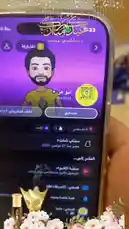 This video provides a close-up view of a Snapchat profile page being displayed on a smartphone. The screen shows a user's Bitmoji avatar, username 'abu3z26', and various story and post options. The phone is held against a backdrop of pink flowers and decorative lights, creating a visually appealing presentation. by @wing_sa with Seoul City by JENNIE