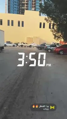This short clip captures a first-person perspective of someone walking through a parking lot. The digital clock overlay shows '3:50 PM'. The person walks past parked cars and a large building before stopping to look down at their phone. An Arabic voice exclaims 'Yeah!' and 'Badashow!' in the background. by @c0_hn with بدأ الشغل 🔥🔥 by os9gg