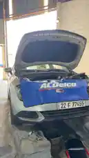 In this step-by-step guide by Wasta Hawkar, viewers see a silver car with its hood open in a workshop setting. A blue ACDelco branded cover is draped over the front grille, highlighting professional-grade automotive parts. The engine bay is visible, with tools and equipment nearby, suggesting a real-world repair or inspection process. This practical, hands-on tutorial demonstrates essential maintenance techniques, ideal for DIY mechanics and car enthusiasts seeking reliable information. by @hawkar_service with original sound