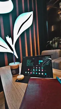 Watch as غازي الحميدي showcases his ideal workspace in a modern coffee shop. This scene captures a perfectly arranged table with a tablet, notebook, and iced coffee, all set against a stylish leaf-themed backdrop. It's a visual guide to creating a productive and inspiring environment. by @ghazi_855 with اشرب قهوتك☕️ by KK9L0