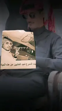 يظهر هذا المشهد حسين المنهالي وهو يجلس في بيئة داخلية، يرتدي ملابس تقليدية سعودية ونظارات شمسية، ويحمل ورقة عليها صورة رجل بزي عسكري تقليدي. تشير النصوص العربية المرئية على الورقة إلى 'النوم عن الغانين' و'هذه الحياة'. المشهد يوحي بأن المنهالي يقدم محتوى تحليلي أو إخباري حول شخصيات سياسية أو عائلات حاكمة، مع التركيز على التفاصيل الخفية أو غير المعروفة. تُستخدم الإضاءة الخافتة والتركيز على الورقة لخلق جو من الجدية والغموض، مما يشجع المشاهدين على متابعة المحتوى للحصول على المزيد من المعلومات. by @hussain.2022a with uo.n21 by Original Sound