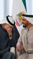 In a candid and warm moment during an official engagement, two Emirati leaders share a laugh. One leader covers his face in amusement while the other smiles broadly, showcasing camaraderie against the backdrop of the UAE flag. This genuine interaction highlights the human side of diplomacy. by @nowaira-11 with original sound