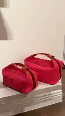 This video showcases two stylish red handbags placed on a clean white surface against a neutral wall. The bags feature bold orange trim and a prominent 'H' logo, suggesting a luxury brand aesthetic. The minimalist presentation highlights the design details, making it ideal for fashion enthusiasts interested in bag styling, product displays, or brand aesthetics. by @lussowatches with original sound