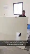 A behind-the-scenes look at a home renovation project. Workers are shown carrying large drywall panels into a room, preparing walls for finishing. The camera then pans across newly installed light-colored laminate flooring, showcasing different sections of the house including a bathroom with a toilet and a hallway with a ladder. A hand points out various areas, highlighting the progress of the work. by @zoodasas with Original Sound by zoodasas