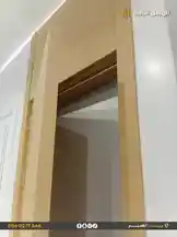 This video showcases a close-up view of a modern interior door installation process by the contracting company 'الهيكل الثابت'. It highlights the craftsmanship involved in fitting a light wood-grain door into a white wall frame, emphasizing clean lines and precise construction techniques. by @fixedstructure with original sound