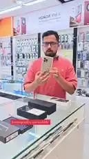 A salesperson at محل السوبر الذهبي للهواتف showcases new Honor X9d 5G smartphones and demonstrates used iPhone models like the iPhone 16 Pro Max and iPhone 17 Pro Max. He highlights competitive prices for various devices including Samsung S25 Ultra, Vivo V60, Motorola Razr 60, and Apple Watch Ultra 3, all with warranty details. The store offers exchange deals and has a wide selection of phones and accessories. by @super_golden7 with Original Sound by super_golden7