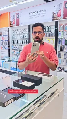 A salesperson at محل السوبر الذهبي للهواتف showcases new Honor X9d 5G smartphones and demonstrates used iPhone models like the iPhone 16 Pro Max and iPhone 17 Pro Max. He highlights competitive prices for various devices including Samsung S25 Ultra, Vivo V60, Motorola Razr 60, and Apple Watch Ultra 3, all with warranty details. The store offers exchange deals and has a wide selection of phones and accessories. by @super_golden7 with Original Sound by super_golden7