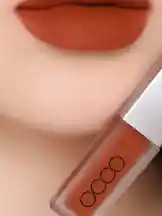 This close-up video showcases a person applying a matte orange lip gloss from OCCO. The camera focuses on the lips as the product is applied, highlighting its rich color payoff and velvety finish. A full view of the product tube is also shown. by @butik.mariya with original sound