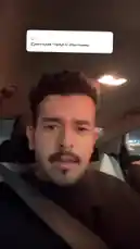 In this candid moment, Abdullah Tale sits in his car at night, responding to a fan's question displayed as Arabic text on screen. He holds up a layered dessert cup while speaking directly to the camera, creating an intimate vlog-style interaction. by @r011.z with Original Sound by r011.z