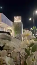 This video captures the tranquil beauty of Sequence Coffee at night. The modern, illuminated building stands out against the dark sky, creating a peaceful urban retreat. In the foreground, delicate white flowers add a touch of natural elegance, contrasting with the sleek architecture. The scene evokes a sense of calm and sophistication, perfect for a quiet evening. The soft lighting and serene atmosphere highlight the inviting ambiance of this contemporary coffee shop. by @sequence-coffee with ياوّرده في كُل الفصول❤️ by W