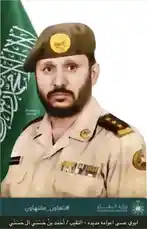 This visual presentation features a formal portrait of Hassani Ahmad in military uniform, set against the backdrop of the Saudi Arabian flag. The image includes Arabic text identifying him as 'Hassani Ahmad' and referencing the Ministry of Defense, suggesting a role within the Kingdom's armed forces. The composition is professional and official, highlighting his rank insignia and national affiliation. by @snap_h24 with original sound