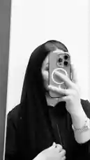 In a striking black-and-white mirror selfie, Raewa Al-Sharqiya, known for her elegant Eastern style, showcases a minimalist yet powerful look. She wears a sleek black hijab and top, holding a modern smartphone with a distinctive MagSafe ring case. Her poised hand gesture and subtle accessories—like a delicate ring and chain-link bracelet—add refined detail. This simple, stylish moment captures contemporary modest fashion with sophistication. by @ru.ab71 with original sound