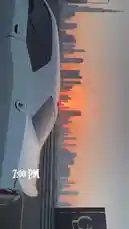 A scenic drive through Dubai during sunset, showcasing a sleek white car cruising along a highway with the city's iconic skyline in the background. The warm orange glow of the setting sun silhouettes the skyscrapers, including the Burj Khalifa, creating a breathtaking urban landscape. This tranquil yet dynamic journey captures the essence of modern Dubai, perfect for travel enthusiasts and cityscape lovers. by @dsunmusic with Original Sound by dsunmusic