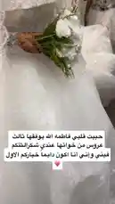 This close-up shot captures the serene beauty of a bride on her wedding day. Her hand, adorned with intricate henna, gently holds a bouquet of pristine white roses and delicate greenery. She is dressed in a stunning white lace gown, showcasing the exquisite details of her bridal attire. by @rii.38 with Original Sound by rii.38